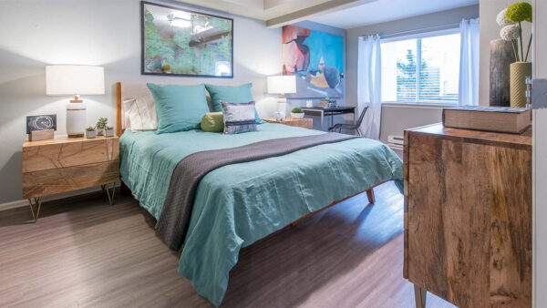 Spacious apartment bedroom with wood floors.