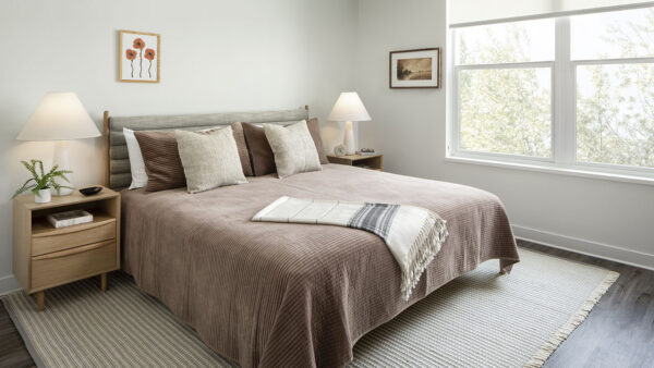 Spacious apartment bedroom with wood floors.