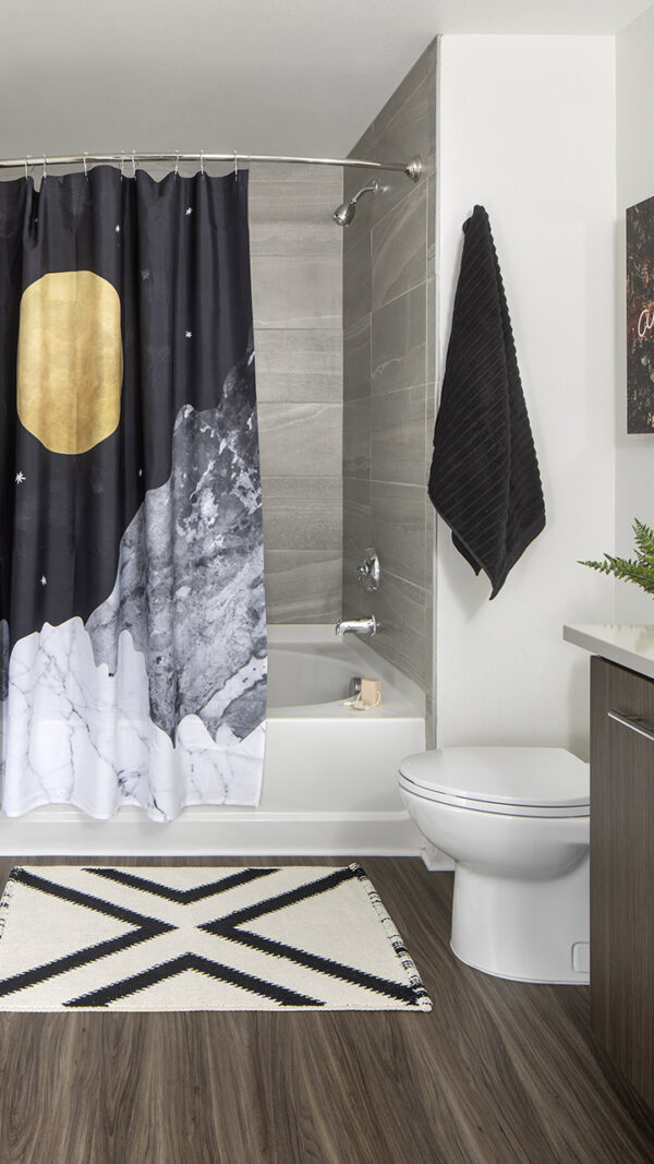 Apartment bathroom with large soaking tub and wood-style flooring.