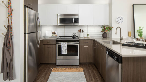 Apartment Kitchen with Stainless Steel Appliances, quartz counters and wood floors.