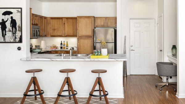 Apartment Kitchen with Stainless Steel Appliances, quartz counters and wood floors.