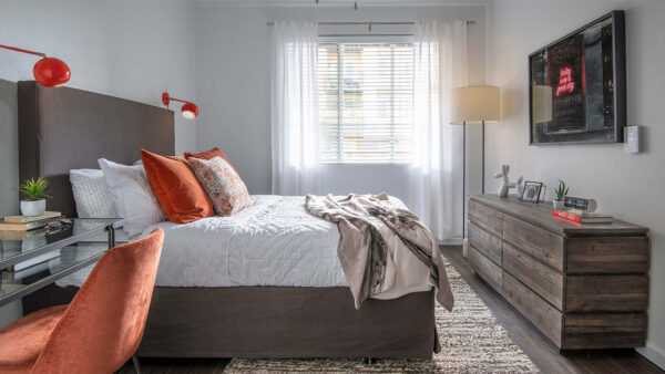 Spacious apartment bedroom with wood floors.