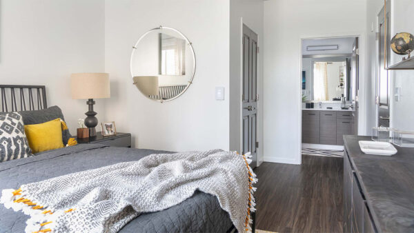 Spacious apartment bedroom with wood floors and bathroom.