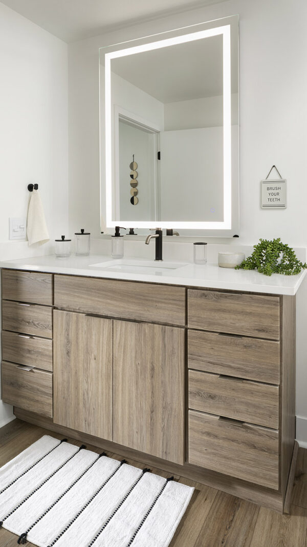 Apartment Bathroom with LED vanity mirror and hardwood flooring.