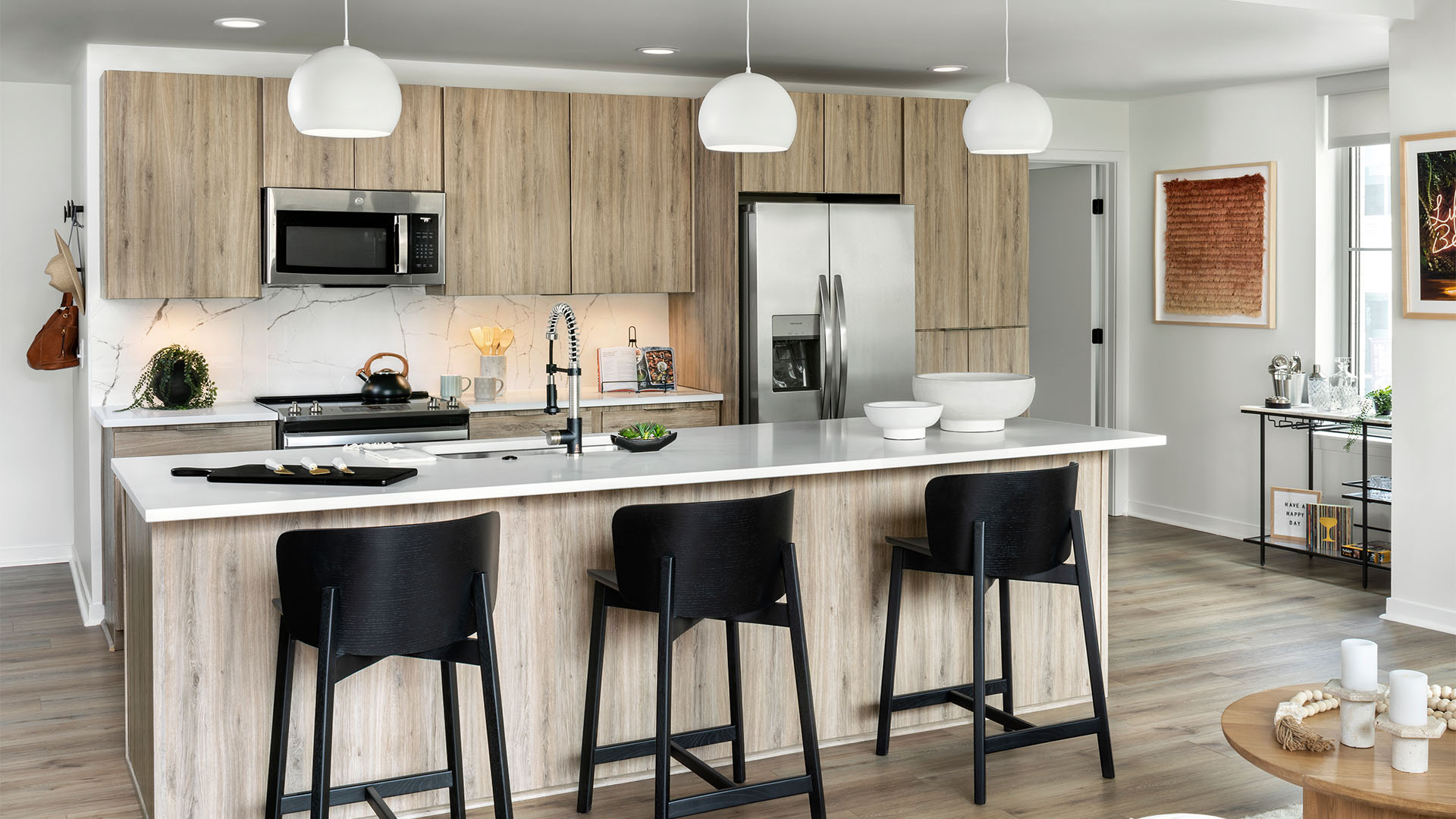 Apartment Kitchen with Stainless Steel Appliances, quartz counters and wood floors.