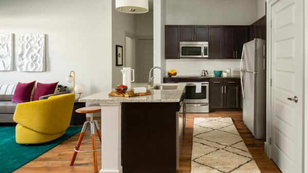 Gourmet Kitchen with Stainless Steel Appliances and Living Room with wood flooring.