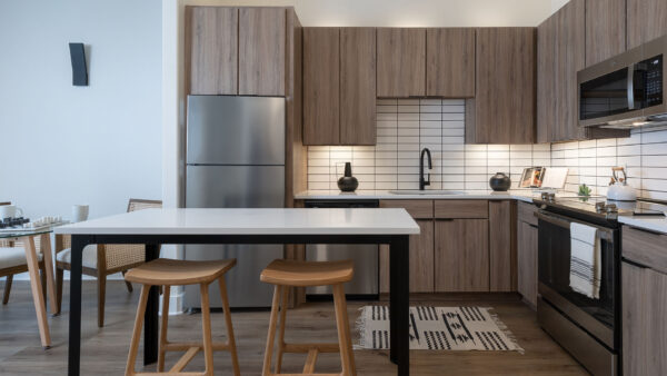 Apartment Kitchen with Stainless Steel Appliances, quartz counters and wood floors.