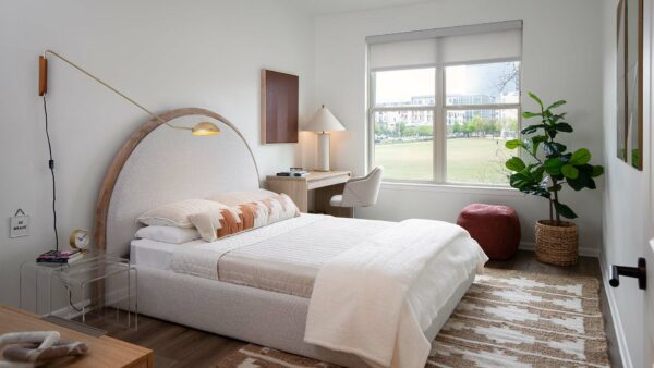 Spacious apartment bedroom with wood-style flooring.