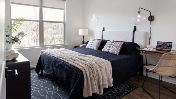 Spacious apartment bedroom with wood-style flooring.