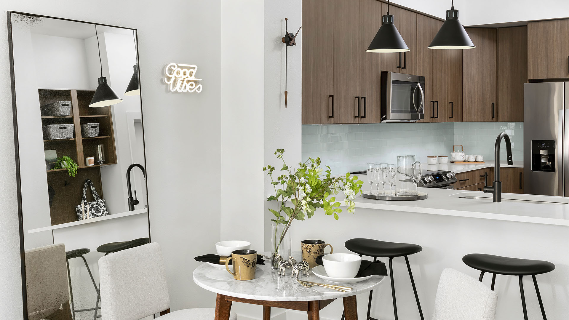 Apartment Kitchen with Stainless Steel Appliances, quartz counters, and wood floors.