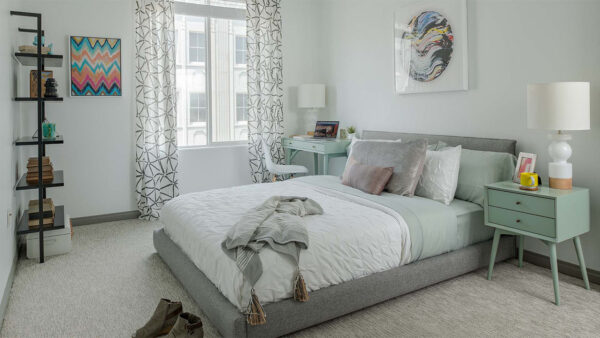 Spacious apartment bedroom with carpeted floors.