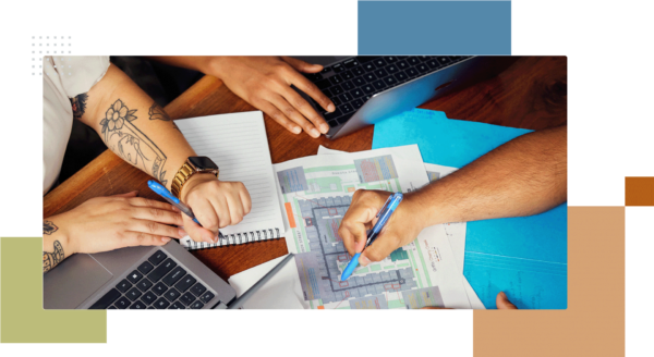 Griffis employees working together at table with laptops and print maps.