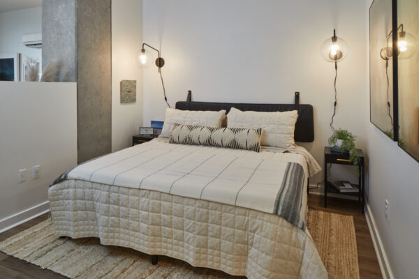 Spacious apartment bedroom with wood-style flooring.