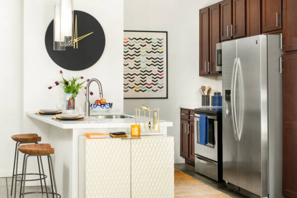 Apartment kitchen with stainless steel appliances, quartz countertops and polished concrete flooring.