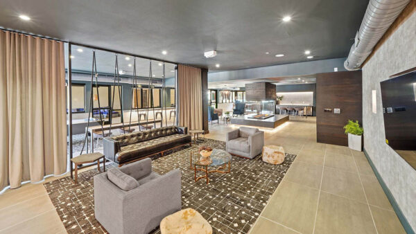 Entertainment lounge with tile floor, comfortable seating, and large TV.