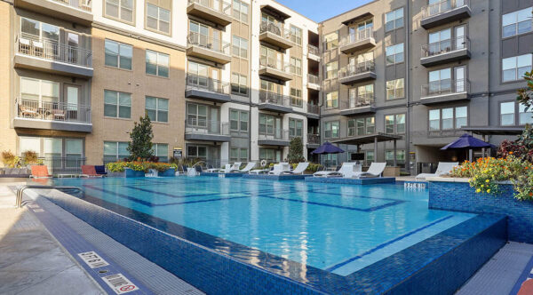Resort-style pool with lounge chairs and gazebos.