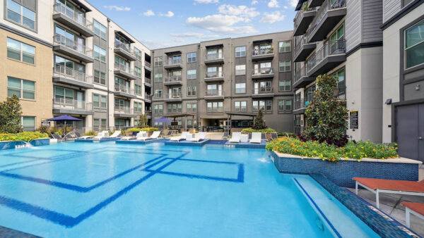 Resort-style pool with lounge chairs and gazebos.