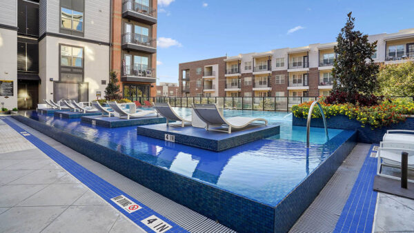 Resort-style pool with lounge chairs and gazebos.