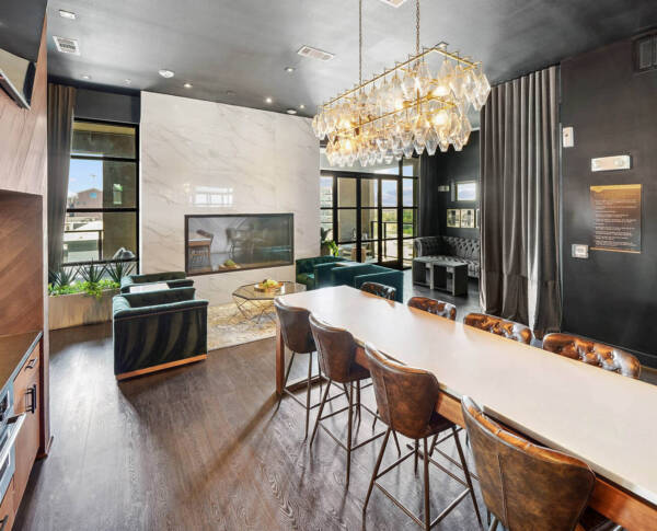 Resident lounge with plush seating, wood style floor, and fireplace.