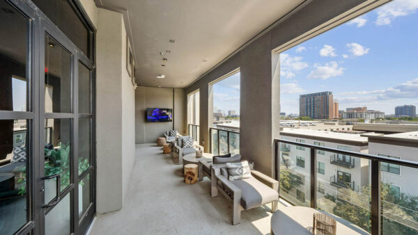 Sky deck with lounge chairs, coffee tables, and TV.