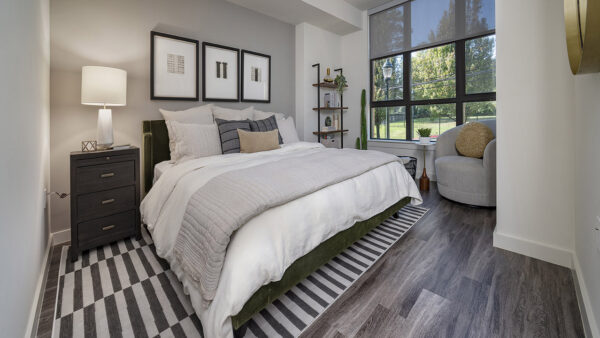 Spacious apartment bedroom with wood-style flooring.