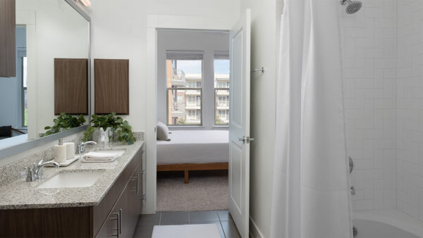 Apartment Bathroom with large soaking tub, double sink, and tile flooring.