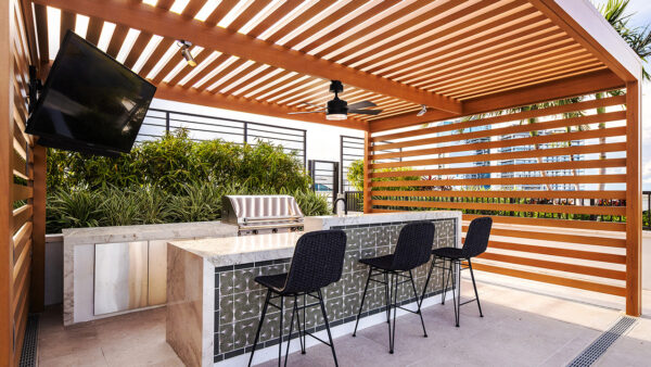 Griffis West Palm apartments rooftop deck with gazebo, BBQ grill, TV, and dining bar.