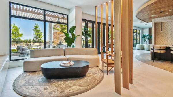 Griffis West Palm apartments resident lounge with plush couch, coffee table with books, and elegant decor.