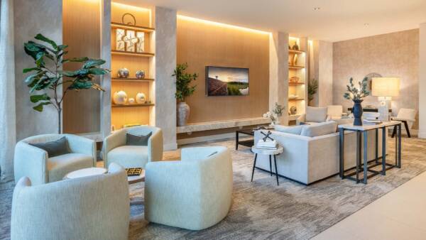 Griffis West Palm apartments resident lounge with plush seating, shelves with decor, and TV.