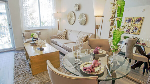 Luxury apartment living room with dining table, modern seating area, and large windows with natural light