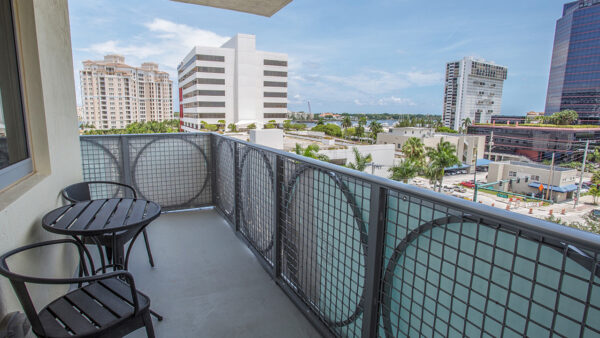 Private luxury apartment balcony with outdoor seating and city skyline views