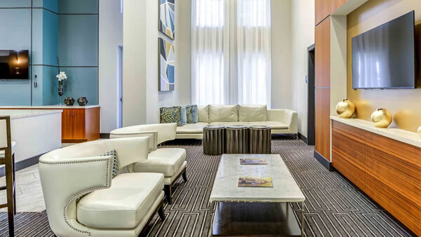 Luxury apartment community lounge with modern seating, coffee tables, and floor-to-ceiling windows