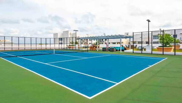 Luxury apartment community rooftop tennis court with city views and professional surface