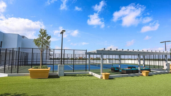 Luxury apartment community tennis court with professional playing surface and open skyline views
