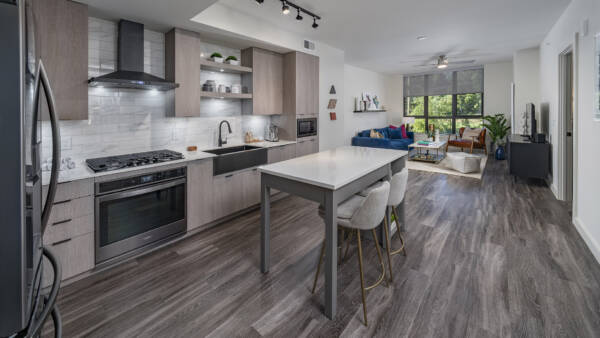 Griffis Edgemoor open-concept apartment kitchen and living room with wood-style flooring.