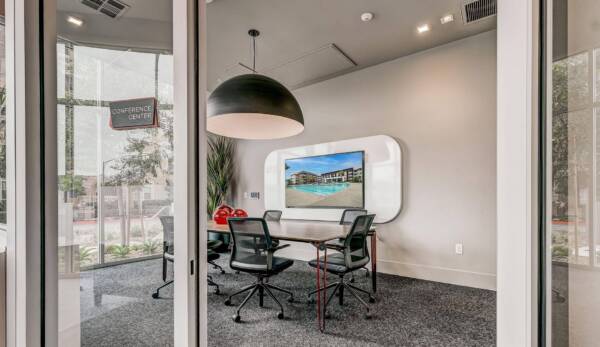 Griffis Platinum Triangle conference room with a pendant light, meeting table, and wall-mounted screen.