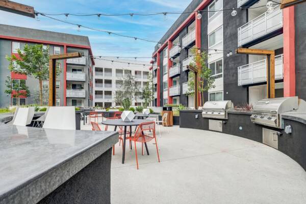 Griffis Platinum Triangle courtyard with outdoor grilling stations, bistro tables, and string lights.