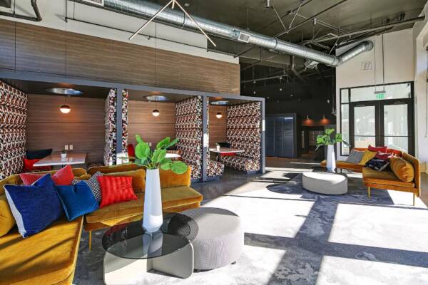 Griffis Shoreline coworking lounge with colorful seating and a brick accent wall.