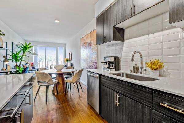 Griffis Shoreline apartment kitchen and dining area with white tile backsplash and wood-style flooring.