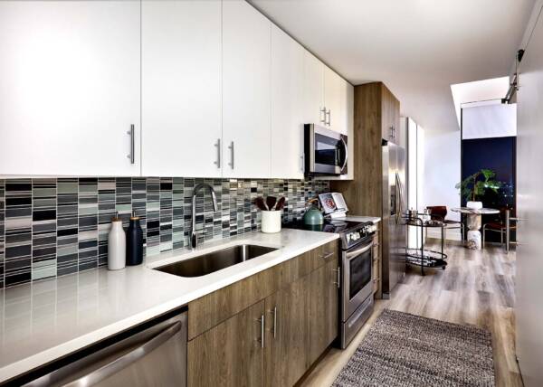 Griffis West Palm Beach apartment kitchen with wood style floor and stainless steel appliances.