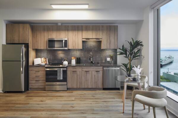 Griffis Seattle Waterfront apartment kitchen with stainless steel appliances, wood cabinetry, and water views