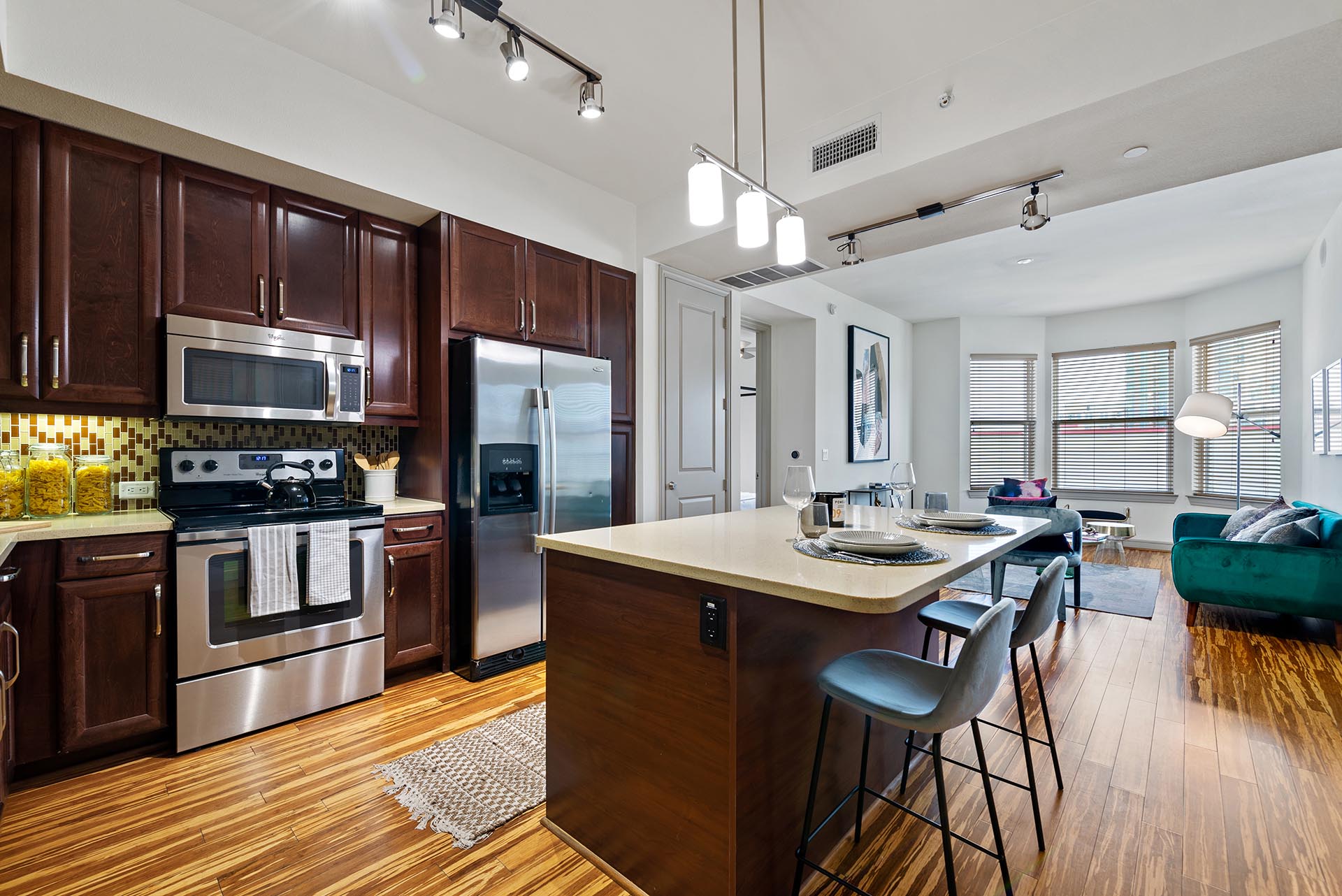 Griffis Uptown apartment kitchen with an island, stainless steel appliances, and an open living area