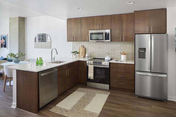 Griffis Platform Union Station apartment kitchen with wood cabinetry, quartz countertops, and stainless steel appliances