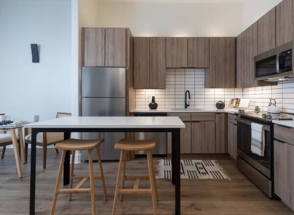 Griffis at The Domain apartment kitchen with wood style floor and stainless steel appliances.
