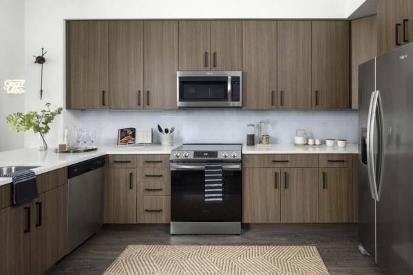 Griffis Cherry Creek North apartment kitchen with wood style floor and stainless steel appliances.