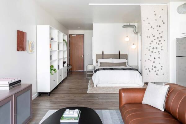Griffis East Village studio apartment living area and bedroom with wood style flooring in San Diego, CA.
