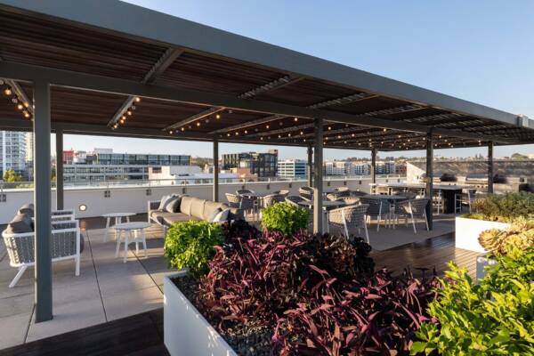 Griffis East Village apartment community rooftop kitchen with dining tables in San Diego, CA..