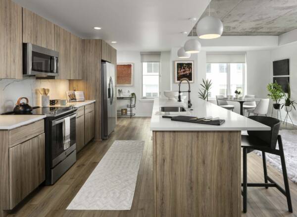 Griffis LoDo apartment kitchen with wood style floor and stainless steel appliances.