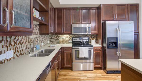 Griffis Uptown apartment kitchen with wood style floors and stainless steel appliances.