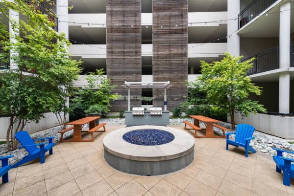 Apartment community outdoor lounge with fire pit and grilling station at Griffis Uptown in Dallas, TX.
